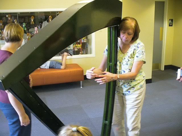 Mom paying a harp at the Children's Museum of Evansville