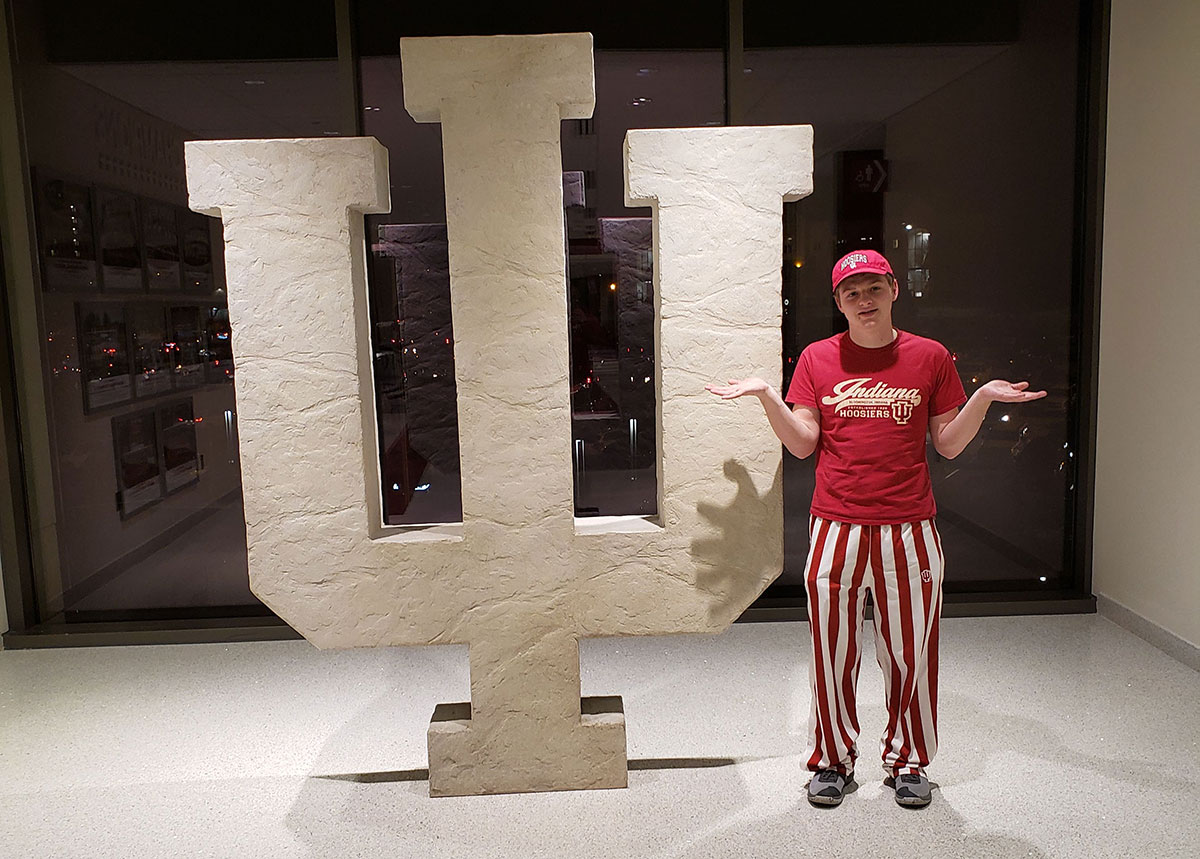 Aiden shrugging shoulders in front of the IU symbol at Assembly Hall where the Hoosiers play basketball