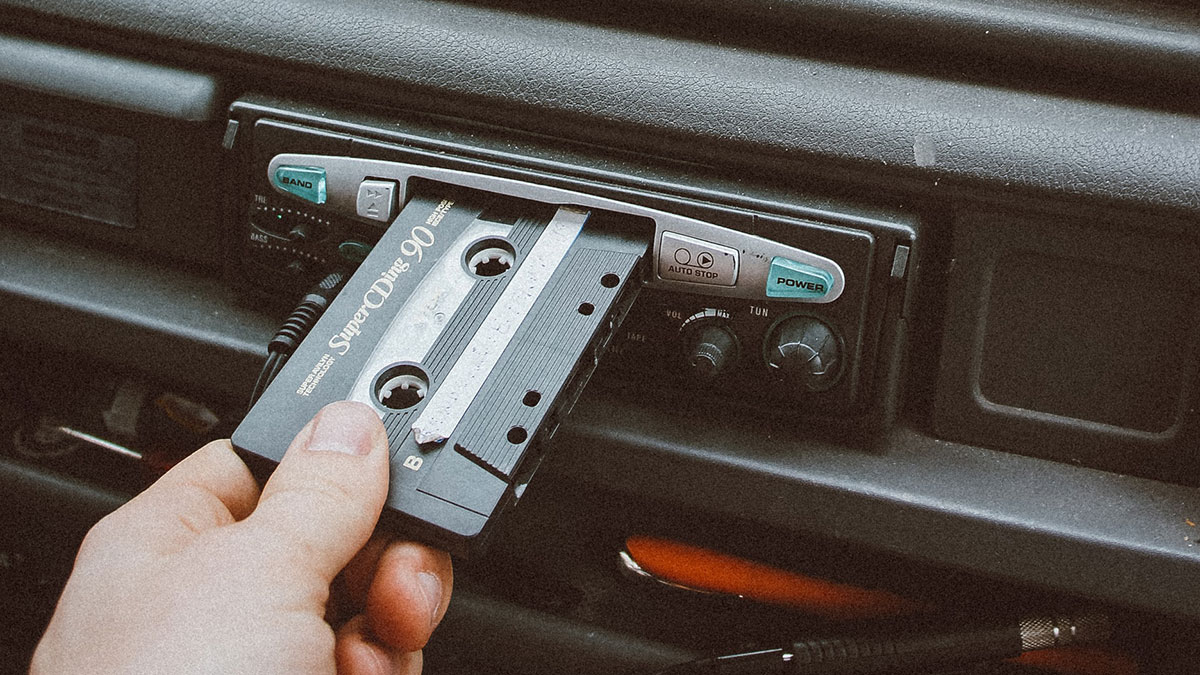 Inserting a cassette tape into a car stereo.
